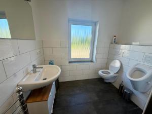 a bathroom with a sink and a toilet and a window at HörneNest Balje - Ferienwohnung zwischen Elbe & Oste in Balje +17 photos