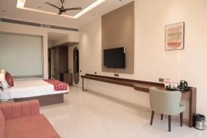 a hotel room with a bed and a flat screen tv at Hotel Sachin in Chas