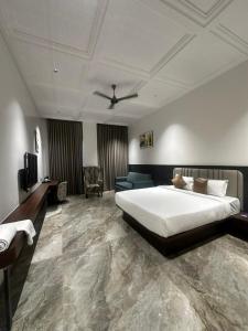 a bedroom with a bed and a couch and a television at Hotel Sachin in Chas