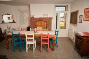 a dining room with a wooden table with colorful chairs at B&Bee alla corte in Dossobuono