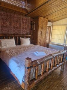a bedroom with a wooden bed in a room at Hotel Riverside Inn - Akhalkalaki in Martuni