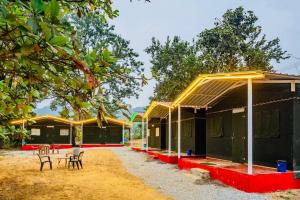 a row of small houses with chairs and trees at Dandeli Kali Resort in Dandeli