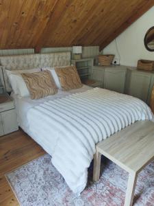 a large bed in a room with a wooden ceiling at Mienru House Self Catering Cottage in Riviersonderend