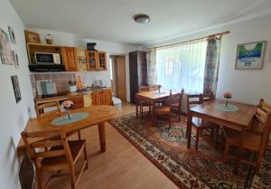 a kitchen and dining room with wooden tables and chairs at Ubytovanie Lienka in Nová Lesná