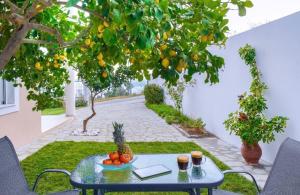 a table with fruit on it in a garden at Fresh Mare Apartments in Limenaria