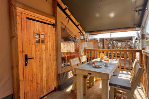a wooden porch with a table and chairs on a deck at Camping Village Bocca di Cecina in Marina di Cecina
