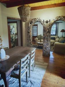 a dining room with a table and a living room at Mienru House Self Catering Cottage in Riviersonderend