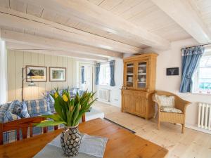 a living room with a couch and a vase of flowers at Haus Quitte in Kühlungsborn