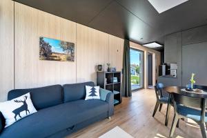 a living room with a blue couch and a table at Chalet Seewald - Tiny House in Seewald