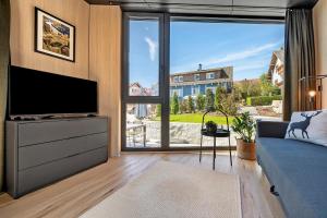 a living room with a tv and a large window at Chalet Seewald - Tiny House in Seewald