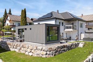 a modular house on a stone wall in front of a house at Chalet Seewald - Tiny House in Seewald