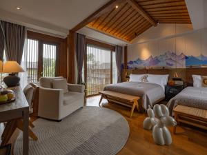 a bedroom with two beds and a living room at PURE Hotel Lijiang in Lijiang