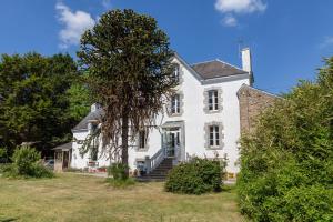 an old white house with a tree in front of it at Kervégant Chambres D'hôtes in Riec-sur-Bélon