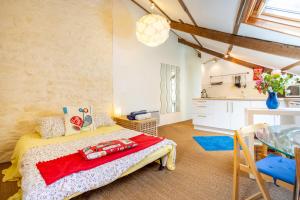 a bedroom with a bed and a table and a kitchen at Kervégant Chambres D'hôtes in Riec-sur-Bélon