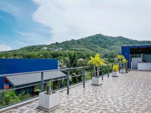 a balcony of a building with a mountain in the background at Kraam Silhouette Hotel and Cafe Phuket- Chalong pier Hotel in Chalong