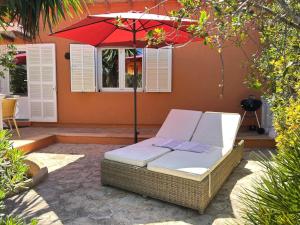 a wicker chair under an umbrella on a patio at Cas Quinto in Cala Ratjada