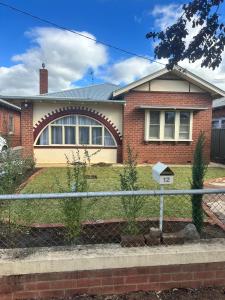 a house with a fence in front of it at Darlow Cottage in Wagga Wagga