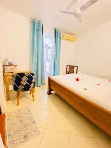a bedroom with a bed and a chair and a window at Hello Rafiki Hotel Stone town in Ngambo