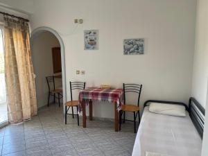 a room with a table and chairs and a bed at Plaka Apartments in Fournoi