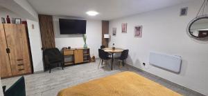 a bedroom with a bed and a table with chairs at Apartament Nova Kamienica - Studio in Łagów