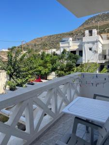a table and chairs on a balcony with a view at Plaka Apartments in Fournoi