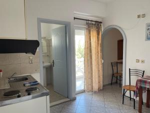 a kitchen with a door open to a patio at Plaka Apartments in Fournoi +13 photos