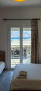 a bedroom with a bed and a sliding glass door at Plaka Apartments in Fournoi