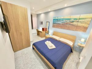 a bedroom with a blue bed and a painting on the wall at VICO 11 Gaeta - UN LETTO IDEALE in Gaeta