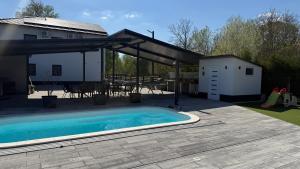 a patio with a swimming pool and a pavilion at Holdruta Vendégház in Kunfehértó