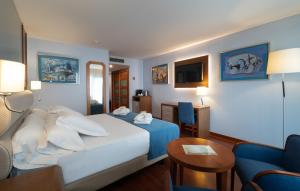 a hotel room with a bed and a tv at Hotel MS Maestranza Málaga Centro in Málaga