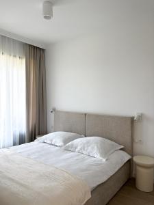 a bedroom with a large bed with white sheets at Omega Lake Apartament Olsztyn in Olsztyn +34 photos