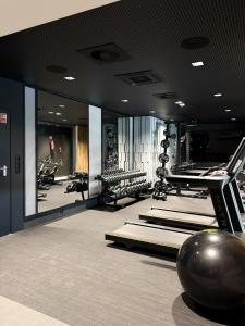 a gym with several treadmills and a ball on the floor at Omega Lake Apartament Olsztyn in Olsztyn