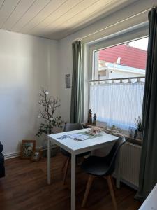 a white table and chairs in a room with a window at Kleine Hafenperle in Varel +5 photos