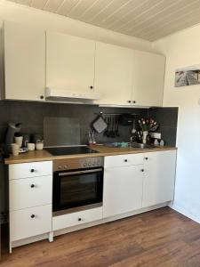 a kitchen with white cabinets and a stove at Kleine Hafenperle in Varel