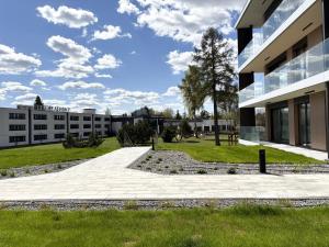 a building with a walkway in front of a building at Omega Lake Apartament Olsztyn in Olsztyn