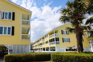 ein gelbes Gebäude mit einer Palme davor in der Unterkunft Sandy Shores III by Capital Vacations in Myrtle Beach