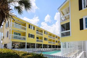 ein gelbes Gebäude mit einem Pool neben einem Gebäude in der Unterkunft Sandy Shores III by Capital Vacations in Myrtle Beach