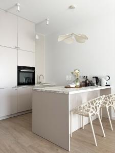a kitchen with white cabinets and a white counter top at Omega Lake Apartament Olsztyn in Olsztyn