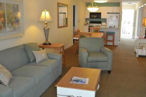 ein Wohnzimmer mit einem Sofa und Stühlen sowie eine Küche in der Unterkunft Sandy Shores III by Capital Vacations in Myrtle Beach