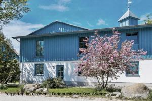 a blue and white house with a tree in front of it at Blinkfüer am Kap Arkona in Putgarten