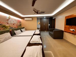 a room with two beds and a flat screen tv at ADITI ROOMS in Tiruchirappalli +25 photos