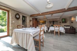 a dining room with tables and chairs and a clock at Maison D'hôtes De Calzac Moulin - in Le Gorvello
