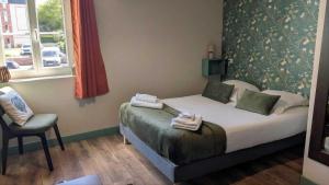 a bedroom with a bed and a chair and a window at L'Authentique in Beaumont-le-Roger +12 photos