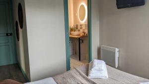 a room with a bed and a bathroom with a sink at L'Authentique in Beaumont-le-Roger