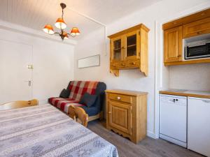 a room with a bed and a chair and a kitchen at Appartement au cœur de La Clusaz, animaux acceptés - FR-1-304-7 in La Clusaz