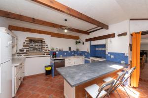 a kitchen with blue and white walls and wooden ceilings at Maison familiale 10 personnes in Bannalec