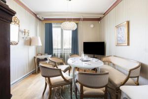 a room with a table and chairs and a television at Radisson Blu Grand Hotel Tammer in Tampere