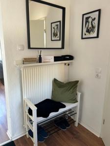 a white bench with a mirror on a wall at Kleine Hafenperle in Varel