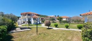 a house with a yard with a tree at 5 Suites Αγιόκαμπος Αγιάς in Agiokampos