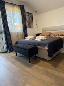 a bedroom with two beds and a ottoman in it at Studio apartman StelLar in Otavice